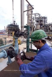 Image du Maroc Professionnelle de  Un ouvrier marocain s'active à fermer une des vannes des systèmes de distributions d'une unité de production de la plus importante raffinerie du Maroc la SAMIR, située à Mohammedia à 30 Km au Nord de Casablanca, le 12 Octobre 2002. (Photo / Abdeljalil Bounhar)